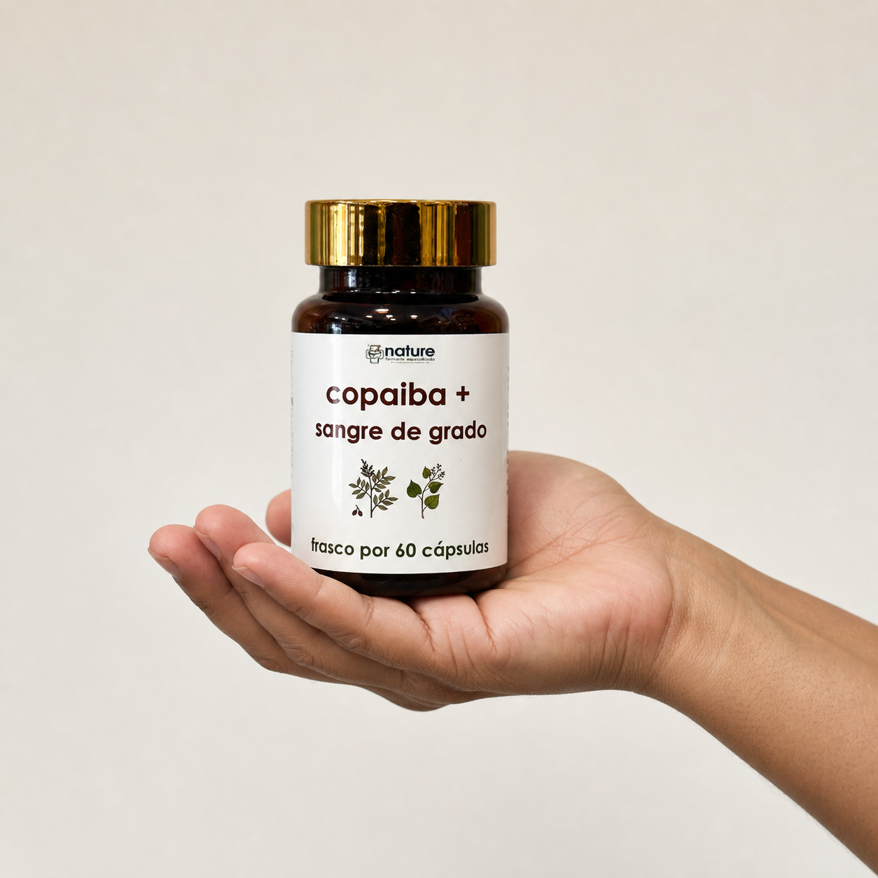 Copaiba + Sangre de Grado — el frasco sostenido en una mano, para ver su tamaño real