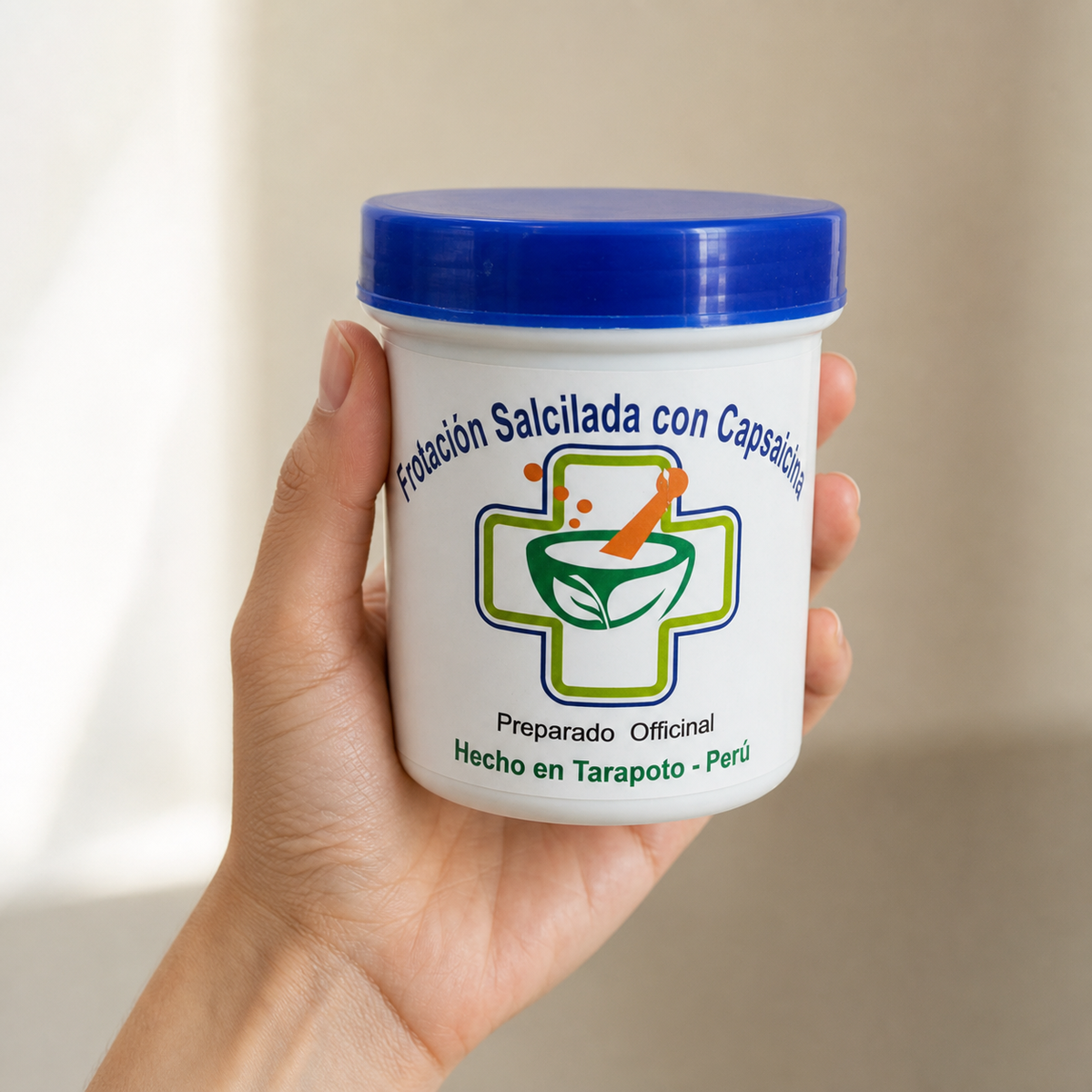 Frotación Salicilada Capsaicinia — el envase sostenido en una mano, para ver su tamaño real