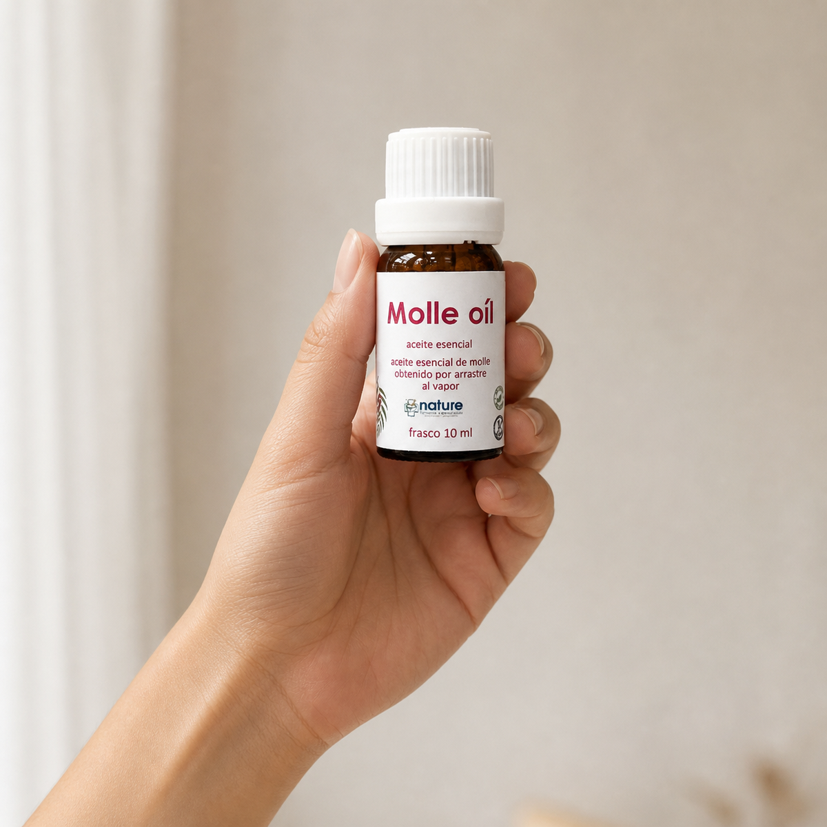 Molle Oil – Aceite esencial de Schinus molle — el envase sostenido en una mano, para ver su tamaño real