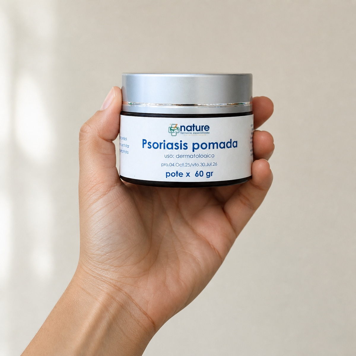 Psoriasis pomada — el envase sostenido en una mano, para ver su tamaño real