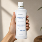 Shampoo Anticaída Revitalizante — el envase sostenido en una mano, para ver su tamaño real