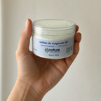 Sulfato de magnesio QP 100 g — el envase sostenido en una mano, para ver su tamaño real